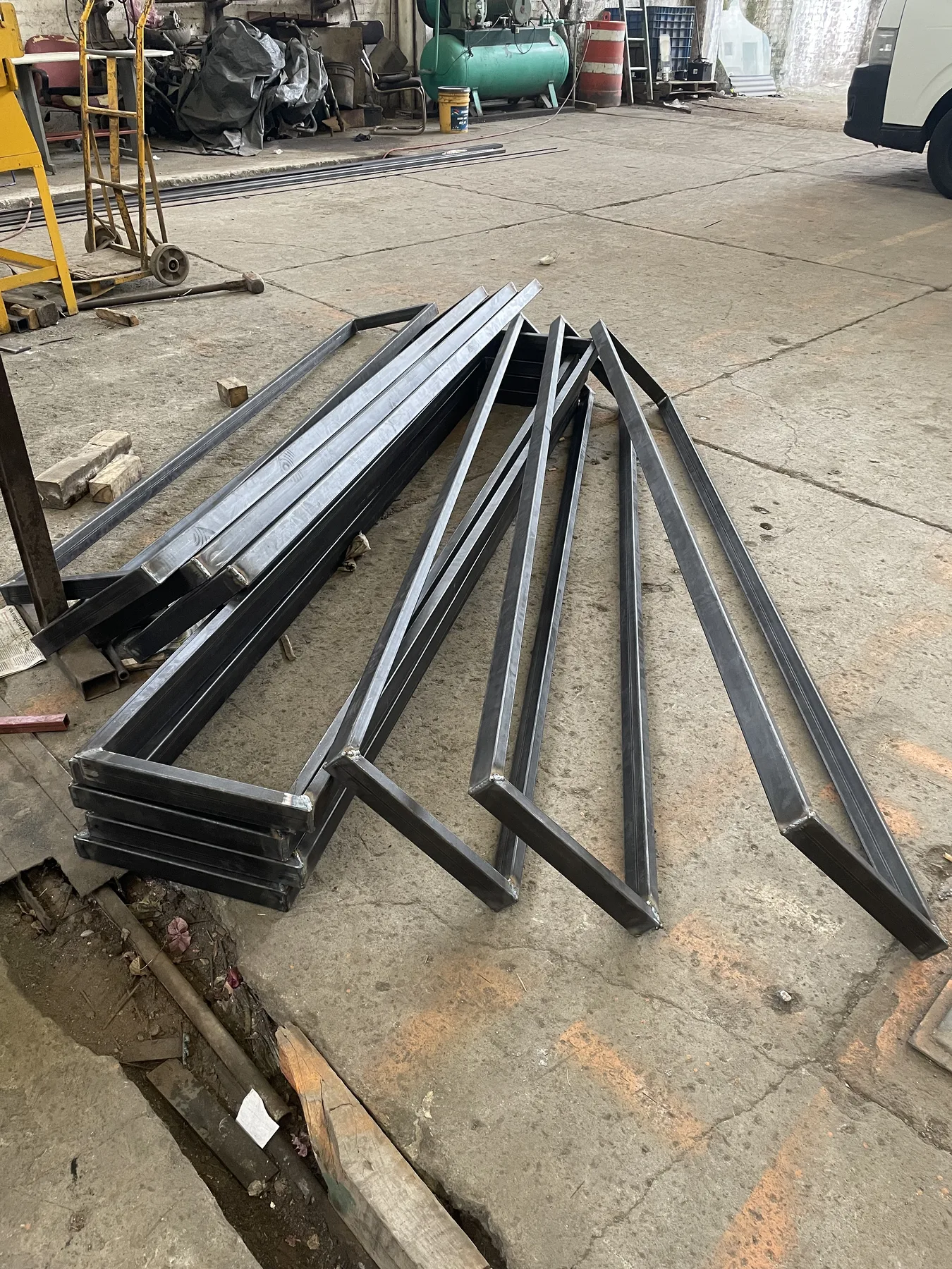 Bastidores triangulares metálicos fabricados y apilados en serie.
