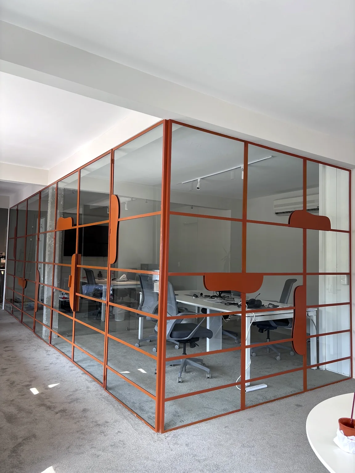 Cancelería metálica color naranja con cristal, fabricada e instalada por HUVE