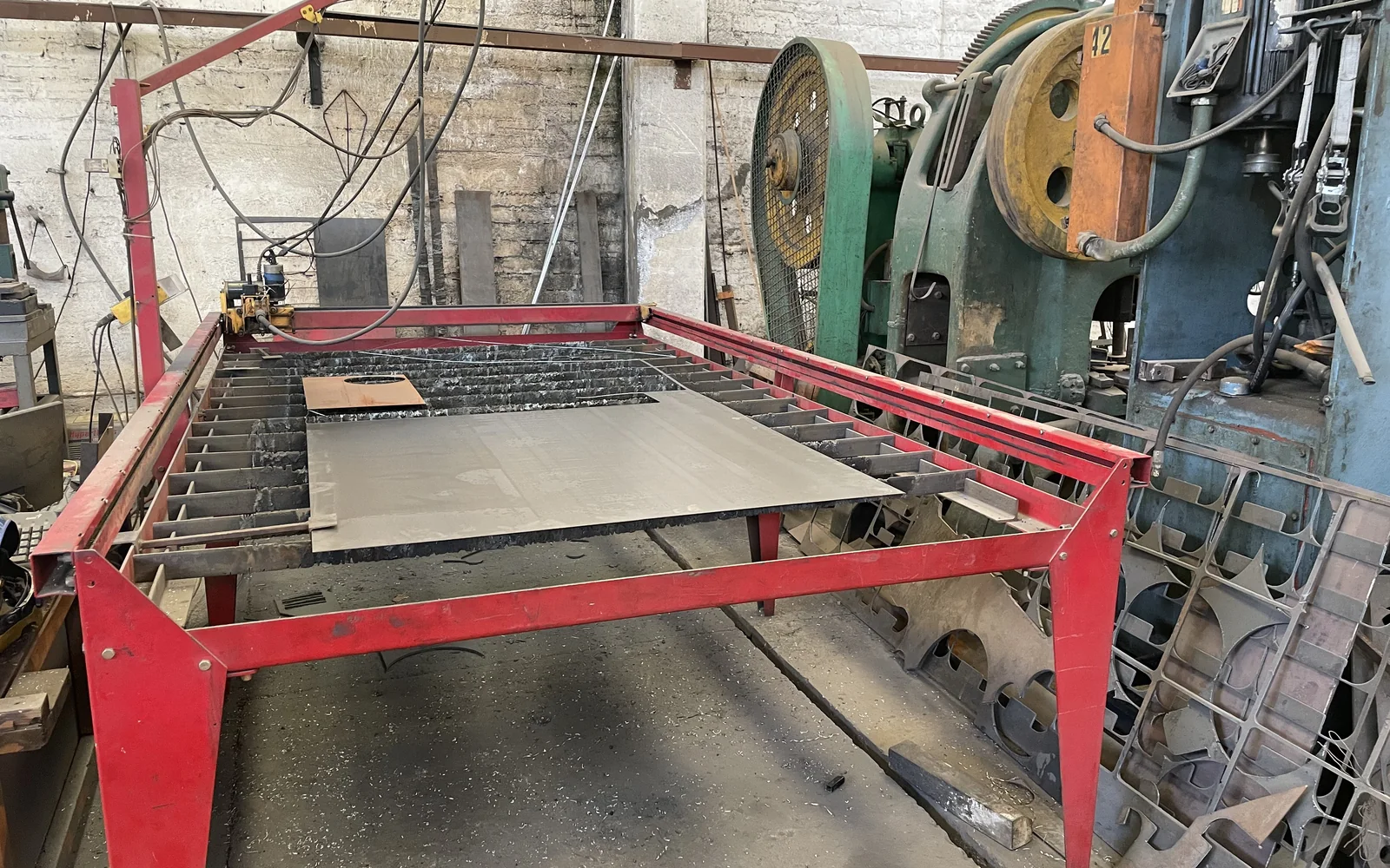 Mesa de corte por plasma CNC con placa de acero preparada sobre la cama de corte.