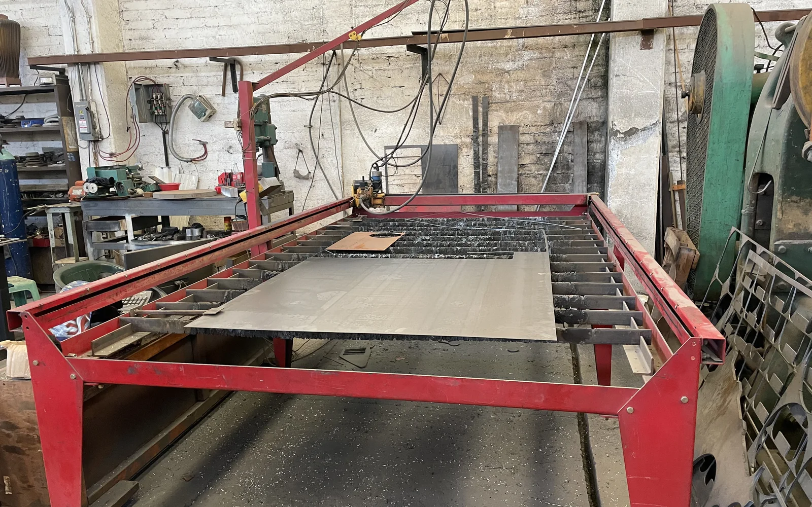 Mesa de corte por plasma CNC con placa de acero colocada para procesamiento.