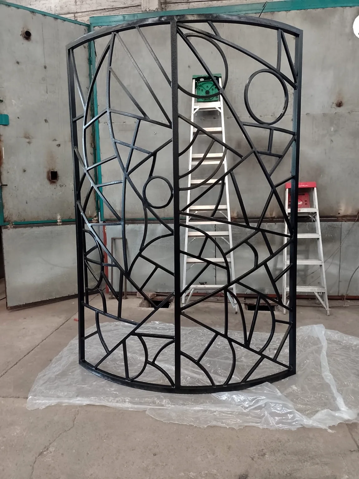 Estructura curva con trazo geométrico y acabado negro, fabricada a la medida.