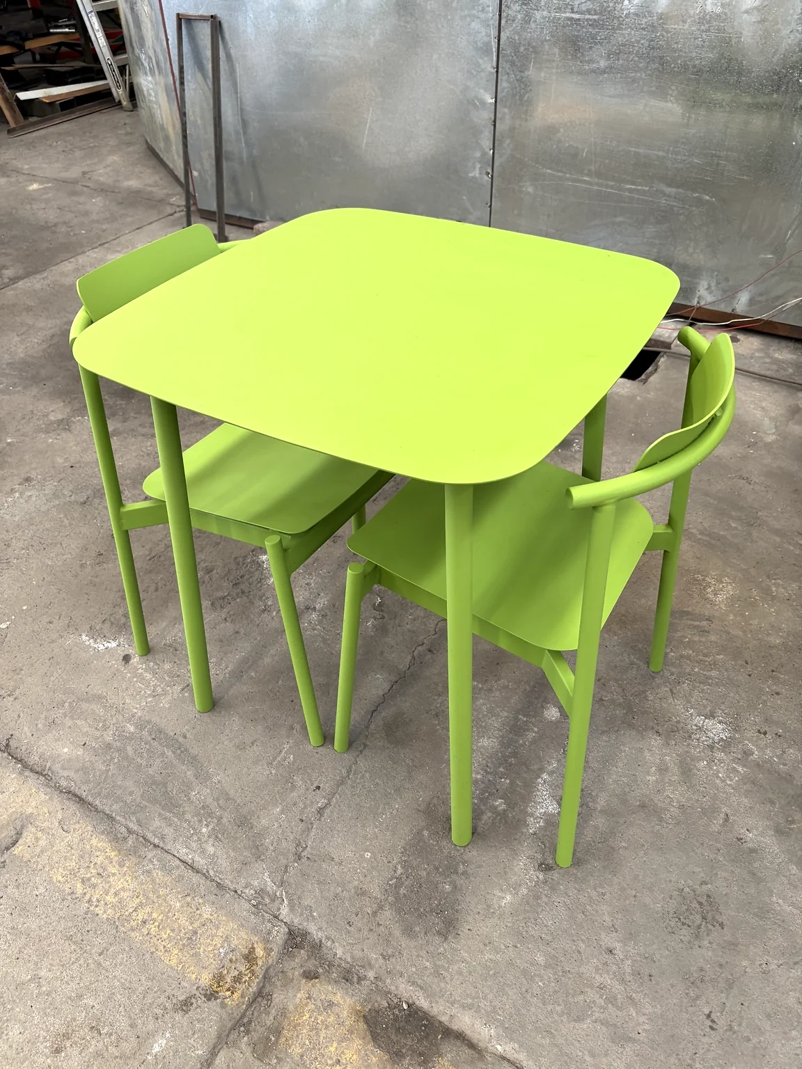 Juego de mesa y sillas metálicas acabado en color verde.