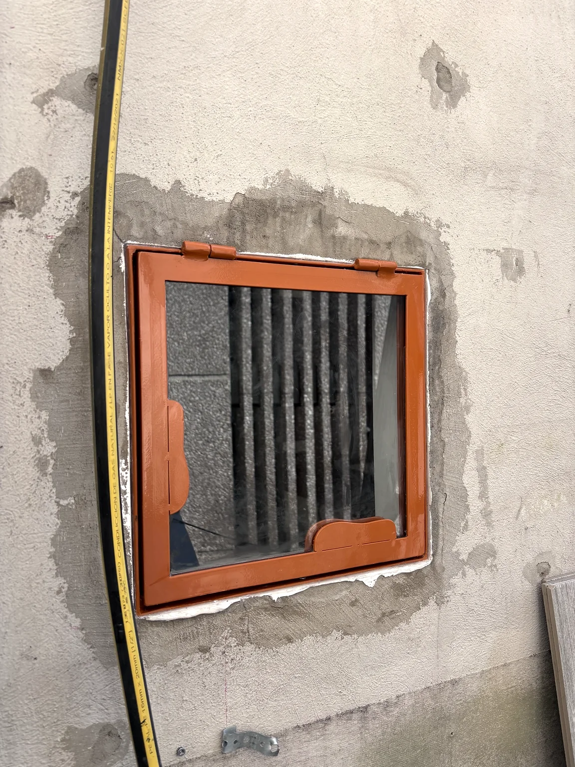 Ventana metálica cuadrada instalada, vista desde el exterior durante la obra.